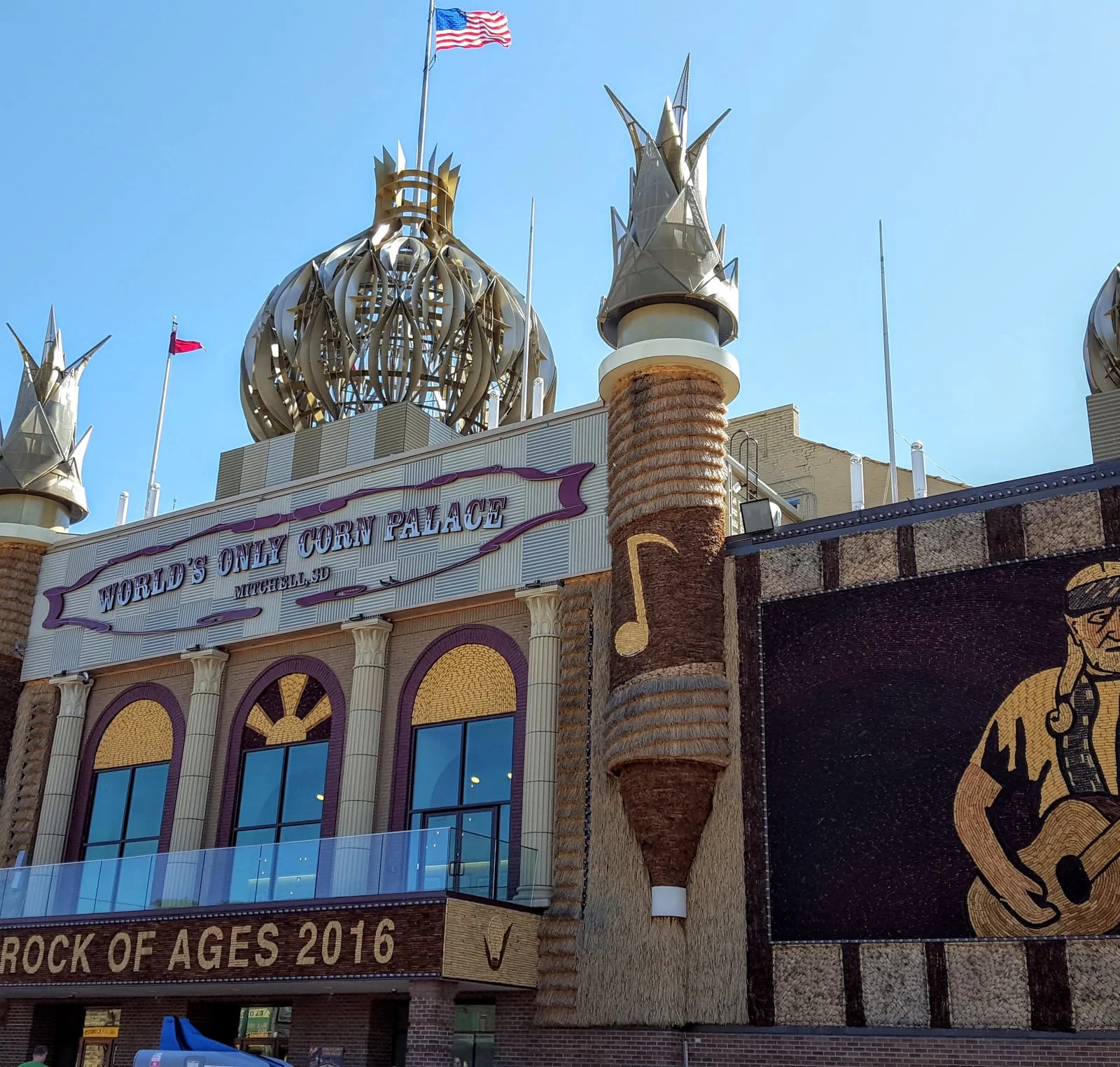 Corn Palace facade with domes and crop murals beneath a Rock of Ages sign