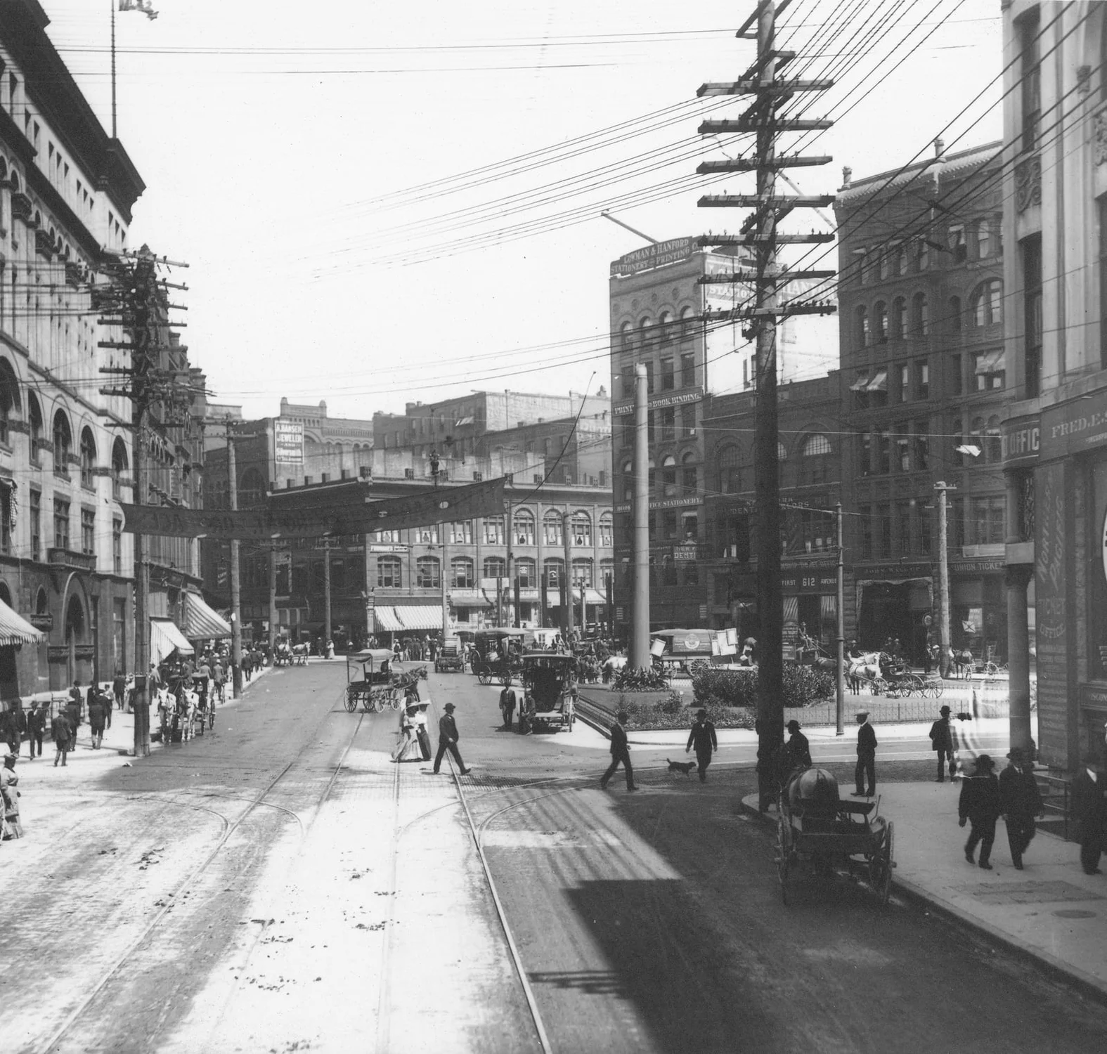 Streetcars and pedestrians on First Avenue South among brick buildings in Seattle in 1901